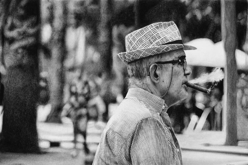 Graphite drawing of a hat-wearing man sitting and smoking on a park bench in Barcelona